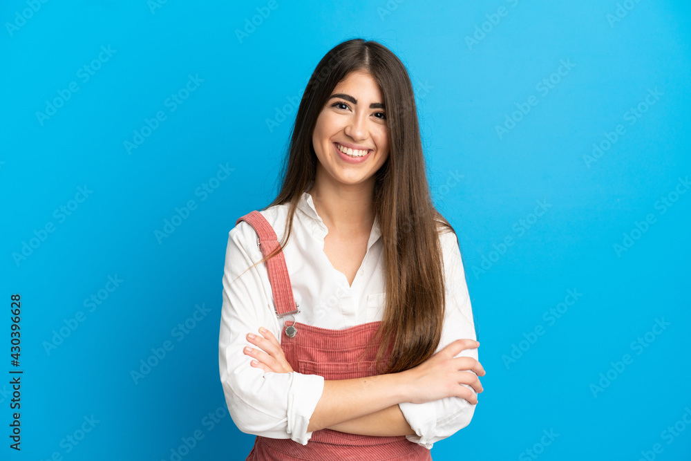 Young caucasian woman isolated on blue background keeping the arms crossed in frontal position Young caucasian woman isolated on blue background keeping the arms crossed in frontal position