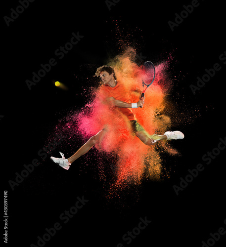 One tennis player in explosion of colored neon powder isolated on black background © Lustre