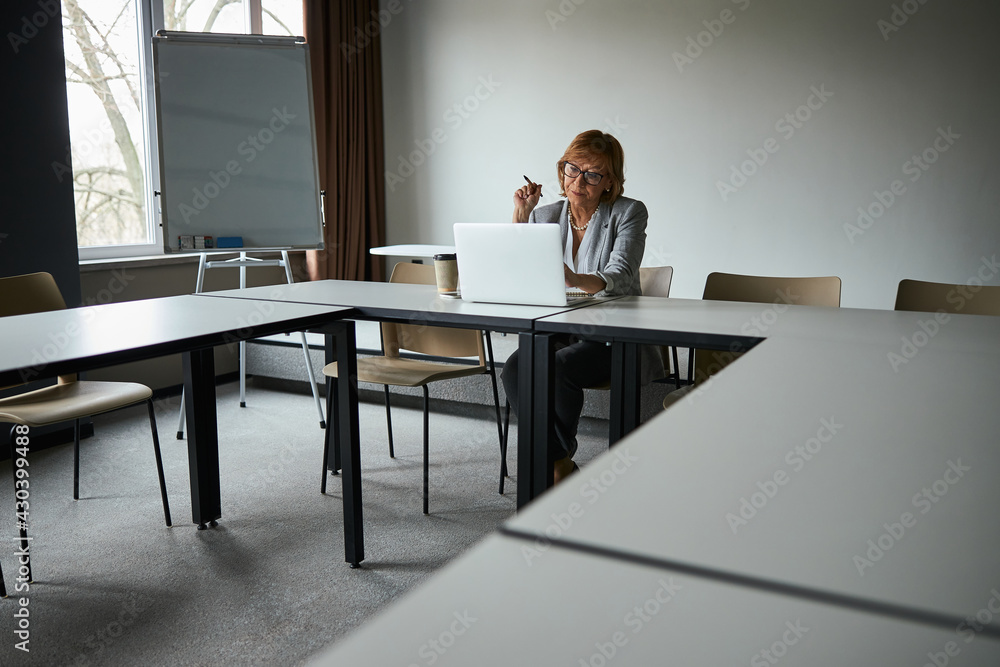 Attentive female sitting in the meeting room alone