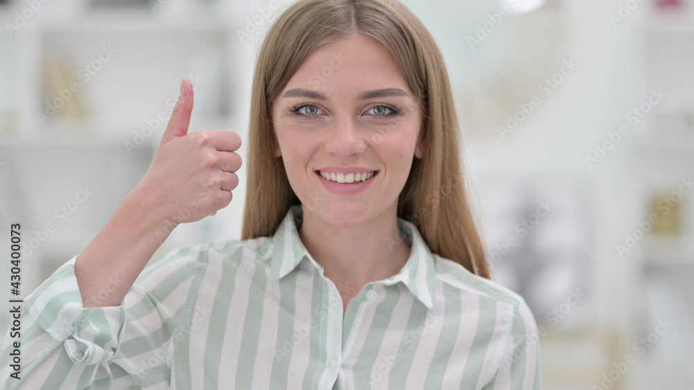 Portrait of Positive Young Woman doing Thumbs Up 