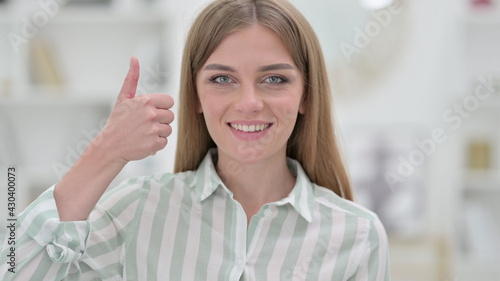 Portrait of Positive Young Woman doing Thumbs Up 