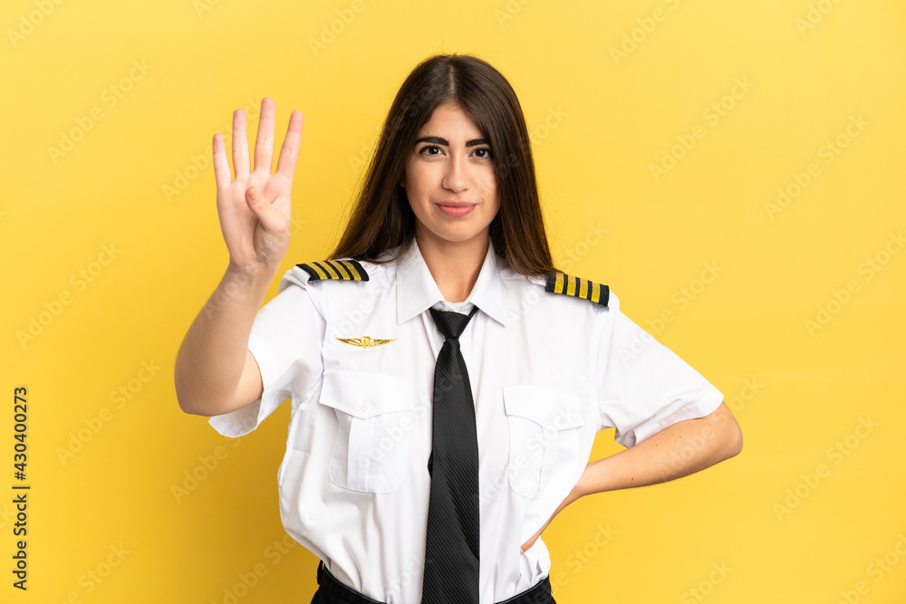 Airplane pilot isolated on yellow background happy and counting four with fingers Airplane pilot isolated on yellow background happy and counting four with fingers