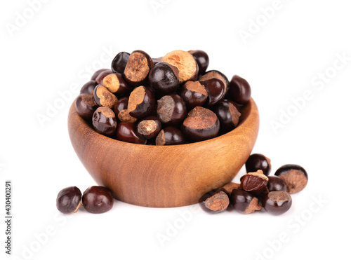 Guarana seed in wooden bowl, isolated on white background. Dietary supplement guarana, caffeine cource for energy drinks. photo