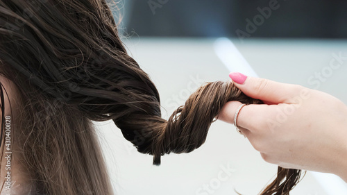 Professional hairdresser washes young woman hair