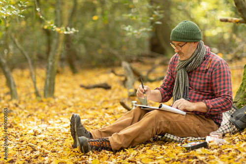 UK, London, Epping Forest, Man painting in Autumn landscape photo