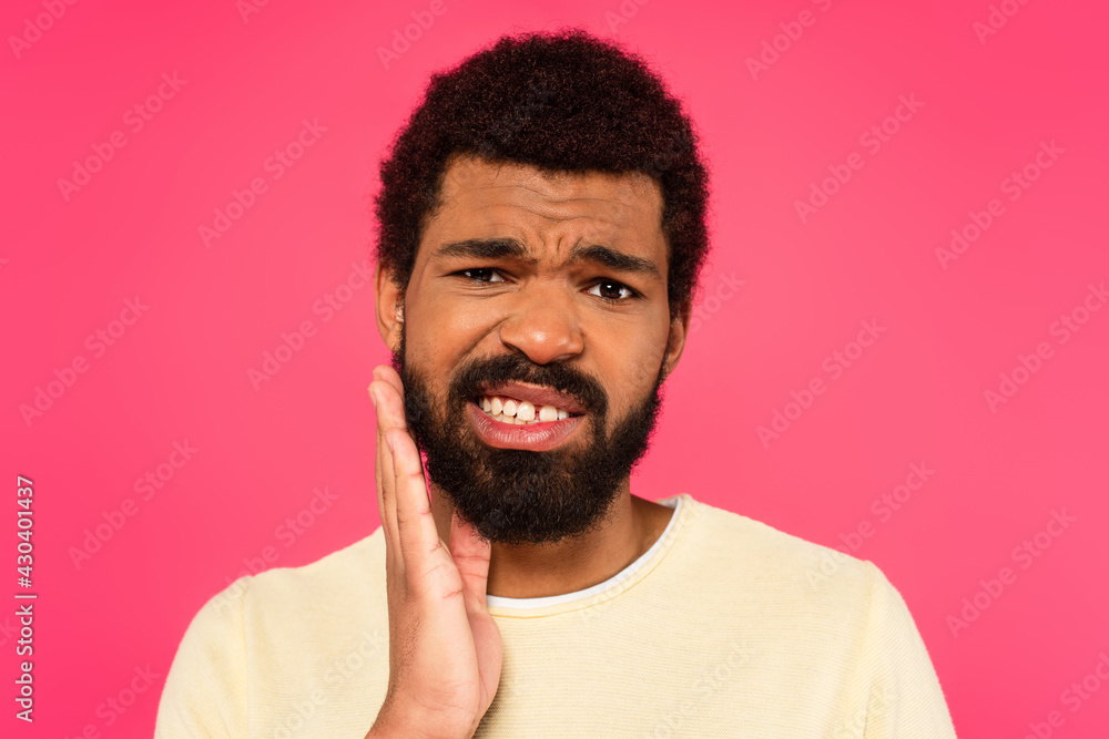 african american man suffering from tooth ache isolated on pink