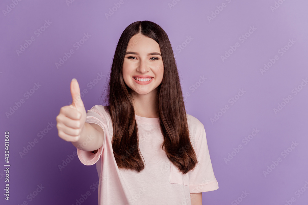 Portrait of woman showing thumb up advice on purple wall Portrait of woman showing thumb up advice on purple wall