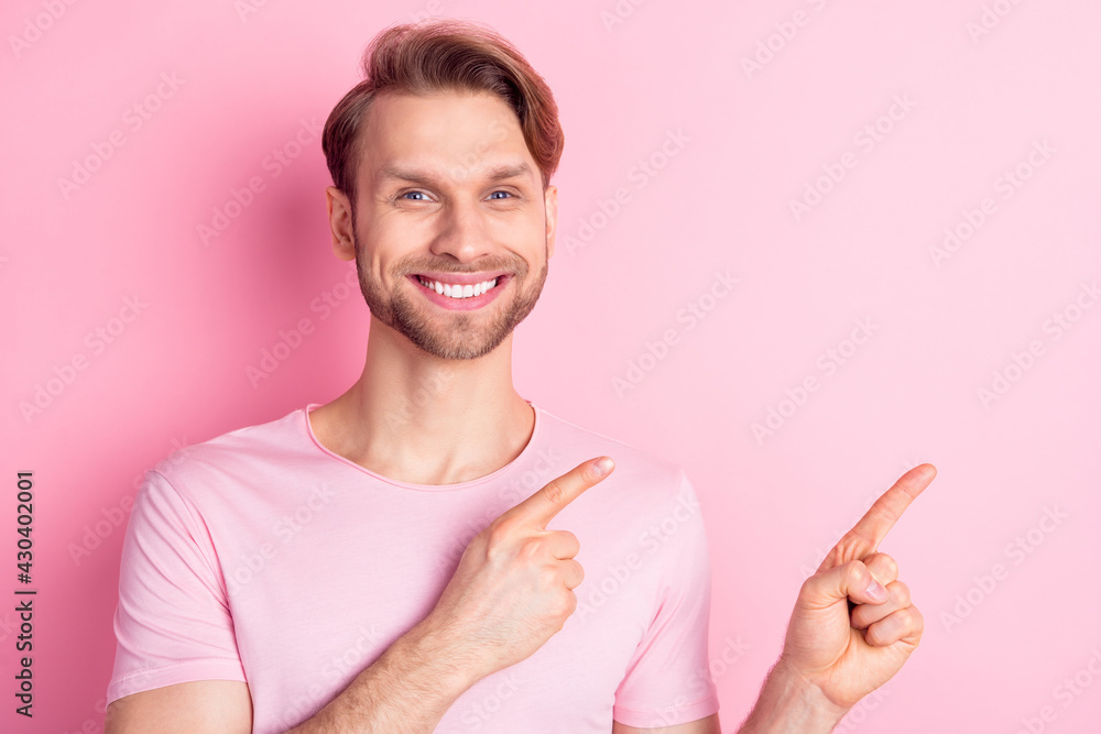 Photo of handsome cool young guy wear casual clothes pointing fingers empty space smiling isolated pink color background Photo of handsome cool young guy wear casual clothes pointing fingers empty space smiling isolated pink color background