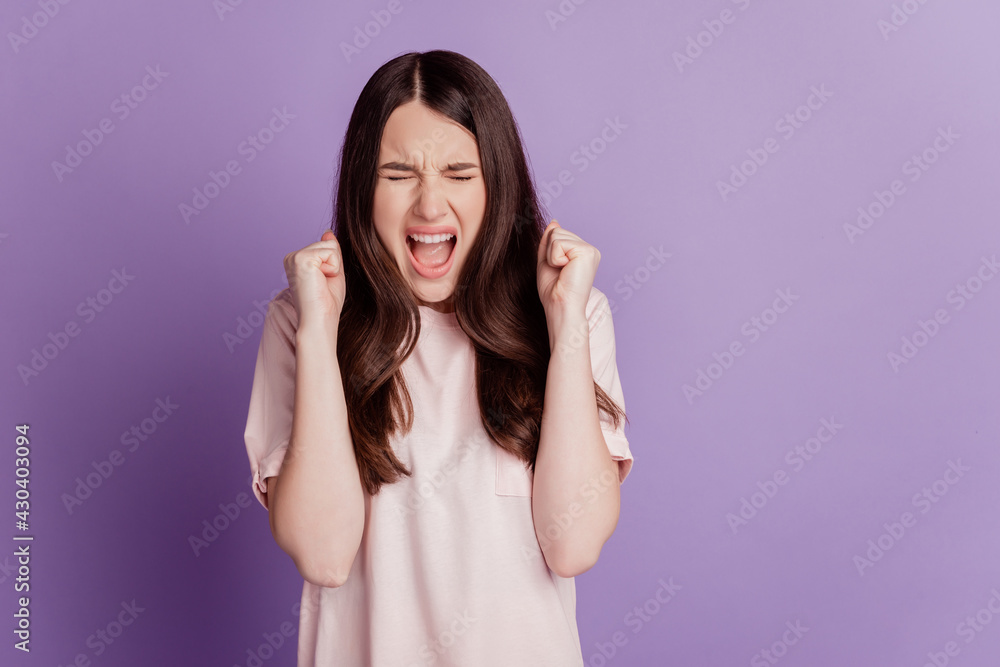 Portrait of astonished winner woman raise fists scream isolated on violet background Portrait of astonished winner woman raise fists scream isolated on violet background
