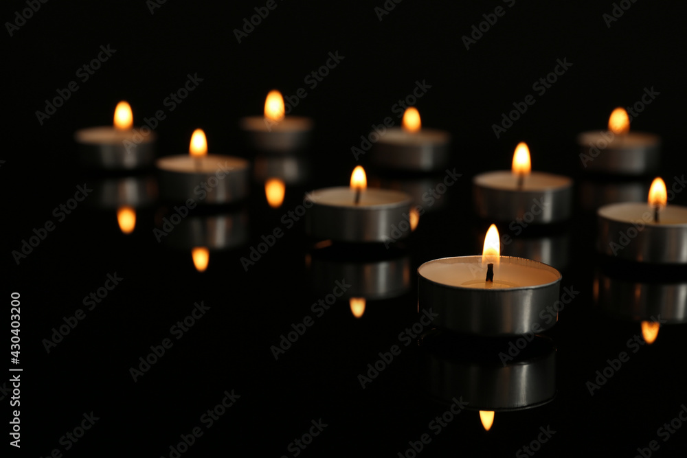 Small burning candles on table in darkness, space for text Small burning candles on table in darkness, space for text