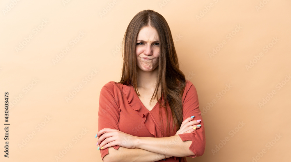 Obraz premium Young caucasian woman isolated on beige background with unhappy expression