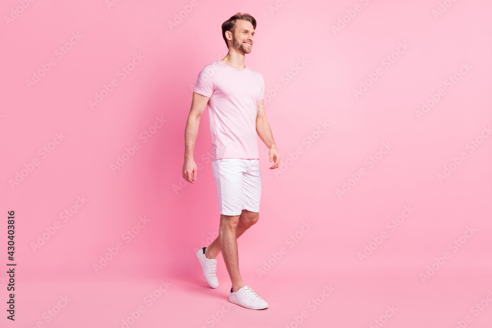 Photo of handsome cute young gentleman dressed casual t-shirt walking smiling looking empty space isolated pink color background Photo of handsome cute young gentleman dressed casual t-shirt walking smiling looking empty space isolated pink color background
