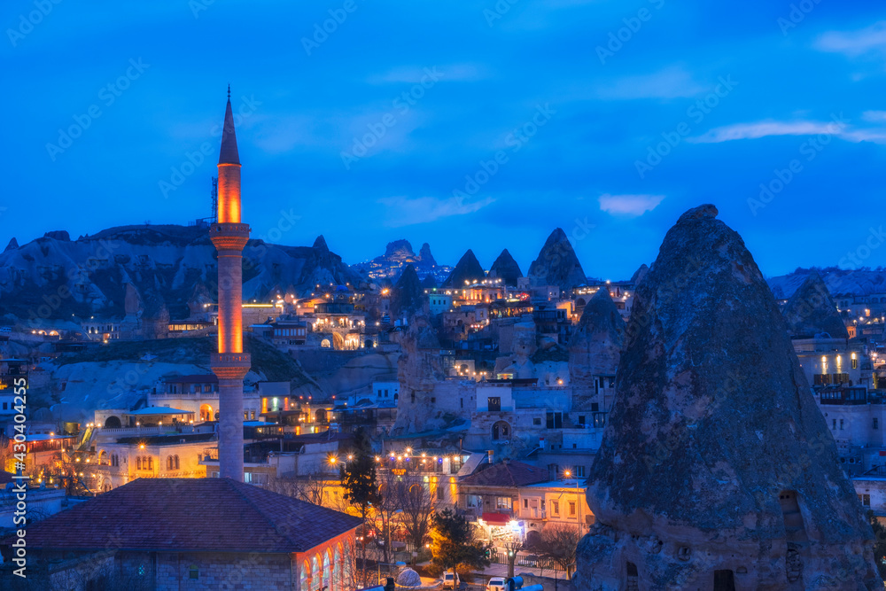 Naklejka premium Landscape of the night city of Goreme, Cappadocia Turkey, overlooking the minaret and houses in the rocks, .blue hour