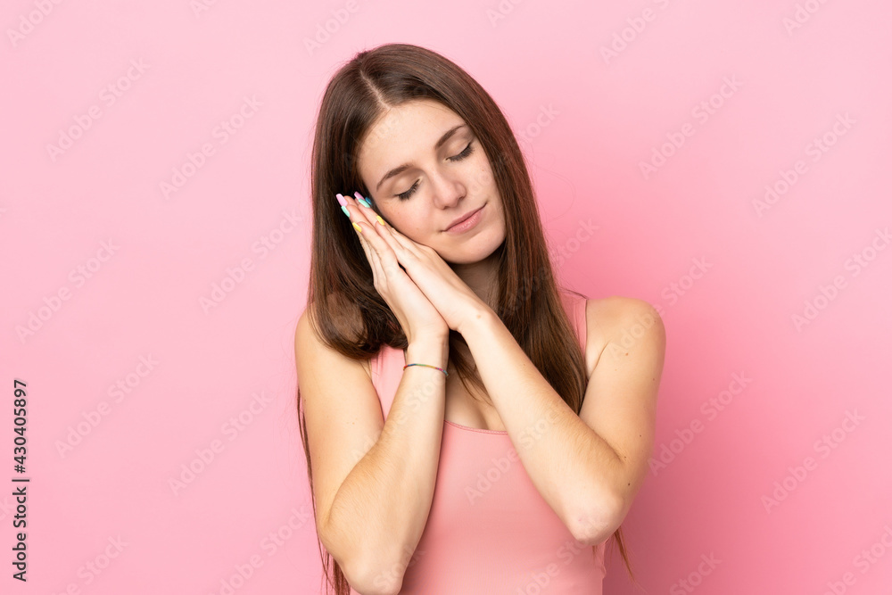 Young caucasian woman isolated on pink background making sleep gesture in dorable expression Young caucasian woman isolated on pink background making sleep gesture in dorable expression
