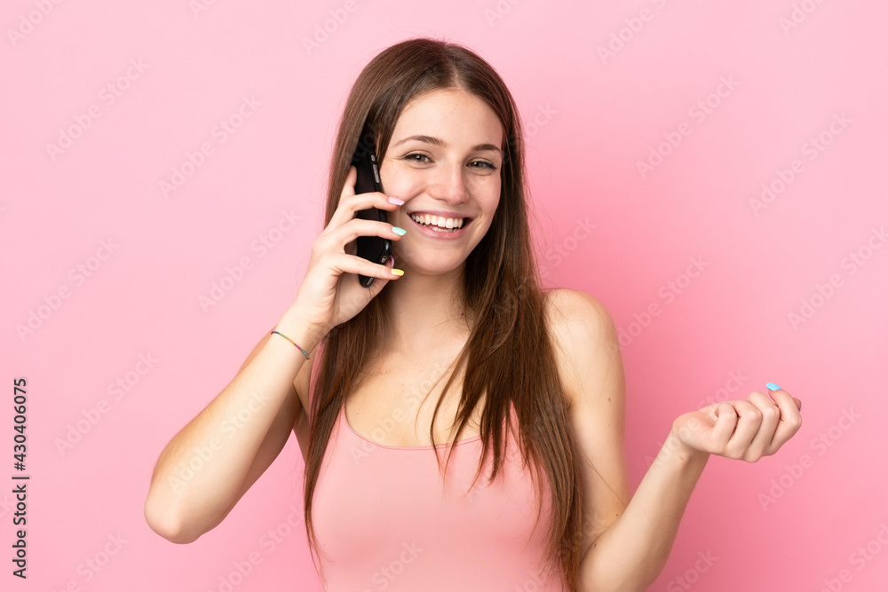 Young caucasian woman isolated on pink background keeping a conversation with the mobile phone with someone Young caucasian woman isolated on pink background keeping a conversation with the mobile phone with someone