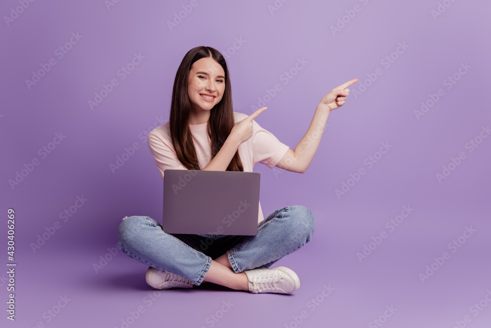 Photo of girl with laptop direct fingers empty space on purple background Photo of girl with laptop direct fingers empty space on purple background