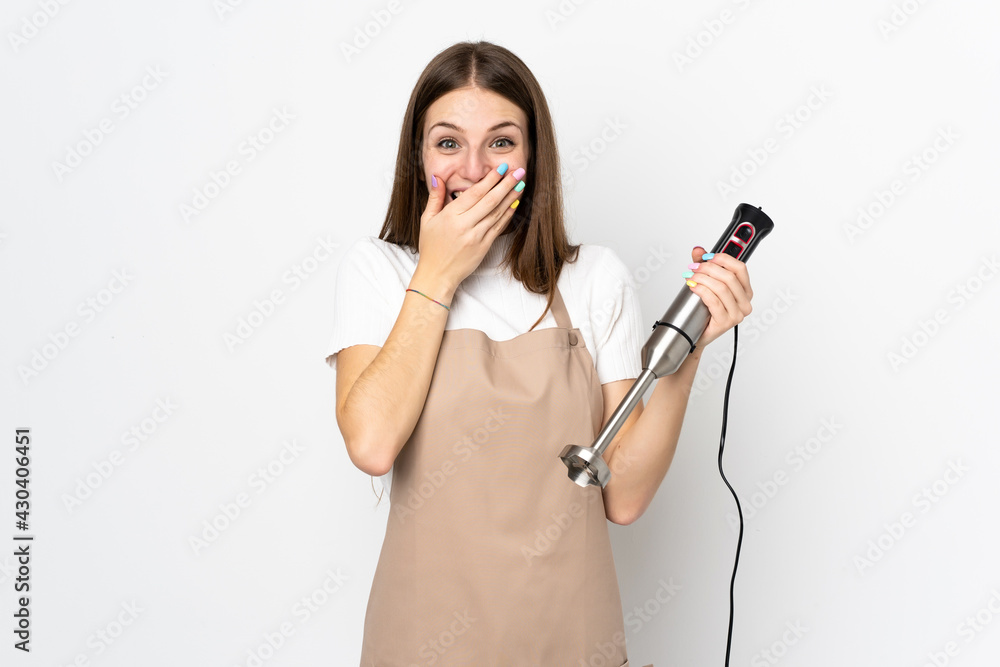 Young woman using hand blender isolated on white background with surprise facial expression Young woman using hand blender isolated on white background with surprise facial expression