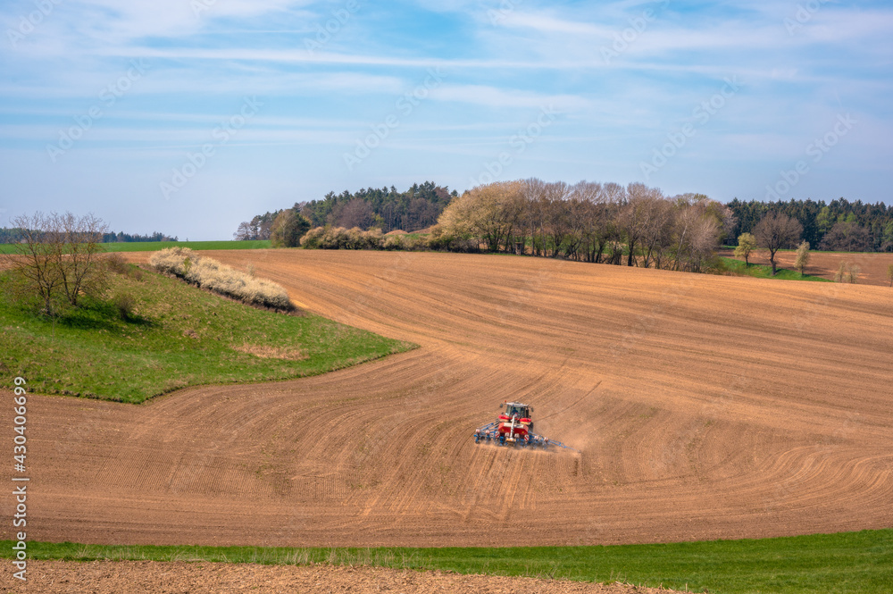 Obraz premium Landwirt beim bestellen der Felder im Frühjahr in Bayern