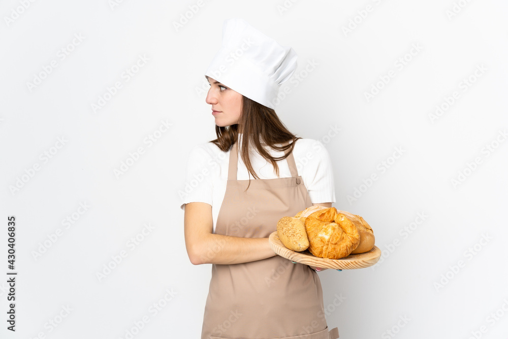 Young woman in chef uniform isolated on white background looking side Young woman in chef uniform isolated on white background looking side