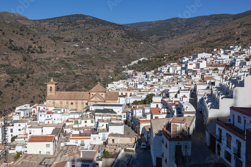 View across white village on the slope of mountain in the Sierra Nevada, Las Alpujarras, Granada Province, Spain photo