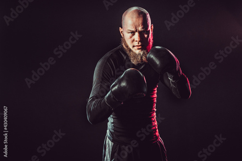 Aggressive bearded boxer on dark background in studio © zamuruev