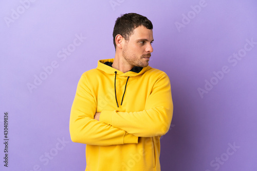 Brazilian man over isolated purple background keeping the arms crossed