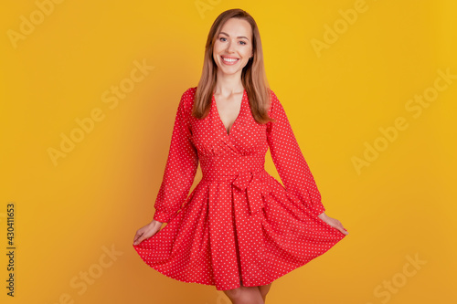 Portrait of lovely woman posing in fancy short dress on yellow wall