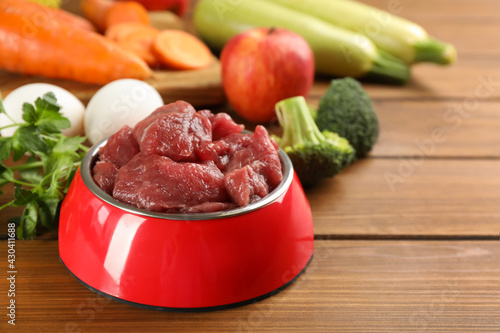 Konstfotografi Raw meat and fresh ingredients on wooden table, closeup