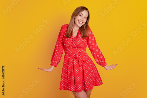 Portrait of stunning adorable woman posing in red short dress on yellow wall