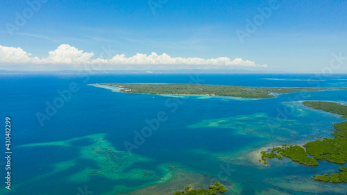 Aerial view of tropical Islands with beaches in the blue sea against the sky and clouds. © Alex Traveler