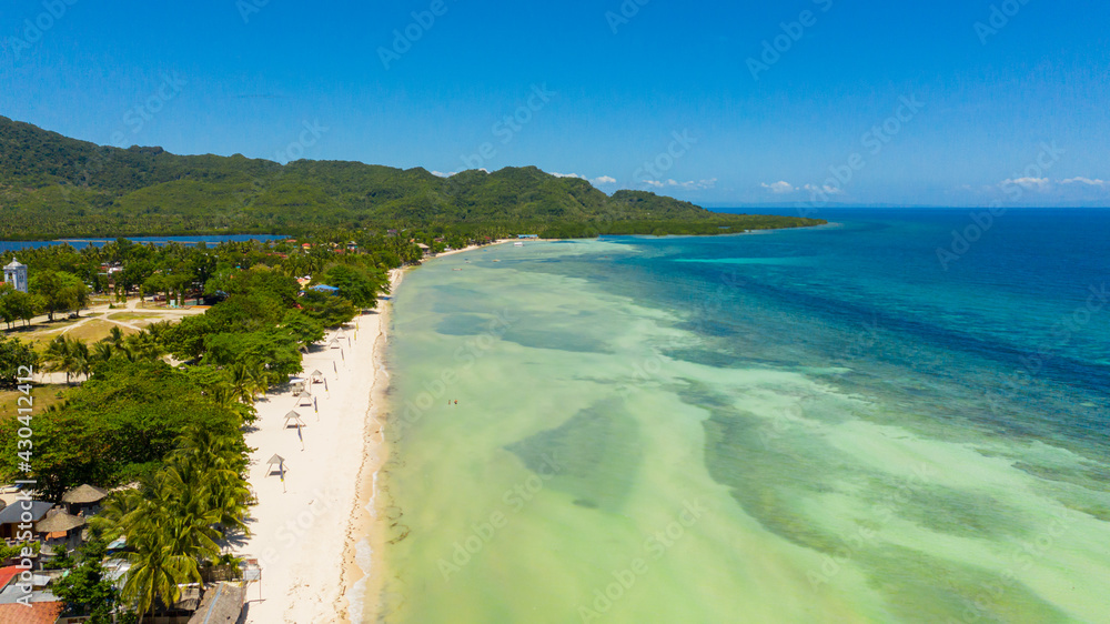 Coast with a sandy beach and azure water surrounded by a coral reef. Bohol, Anda, Philippines. Summer and travel vacation concept.