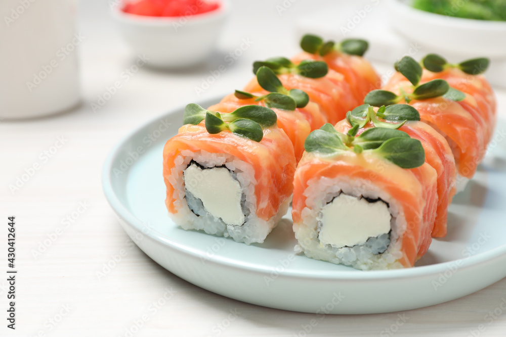 Tasty sushi rolls with salmon served on white table, closeup Tasty sushi rolls with salmon served on white table, closeup