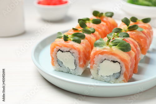Tasty sushi rolls with salmon served on white table, closeup