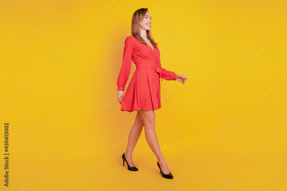 Full length body size profile photo of confident girl walk on yellow background in fancy red short dress