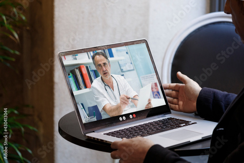 Video chiamata tra un paziente e un medico curante attraverso un computer  in contesto casalingo photo