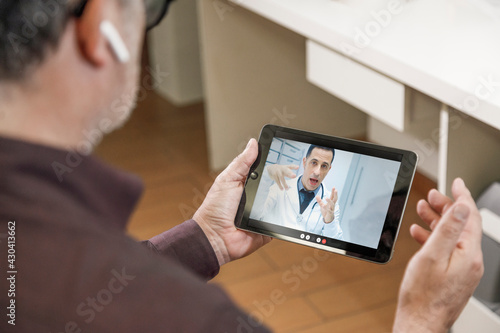 Video chiamata tra un paziente e un medico curante attraverso un tablet in contesto casalingo