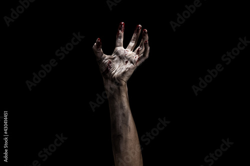 Creepy bloody zombie hand over dark background with clipping path. Horror and Halloween theme. © raland