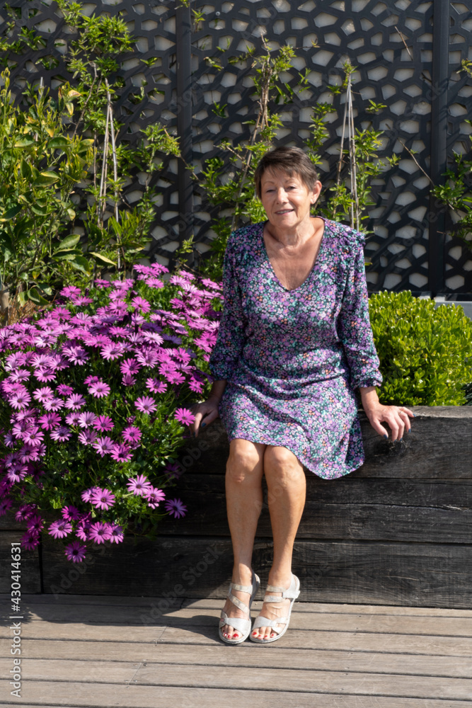 Naklejka premium Happy senior woman sitting in the garden