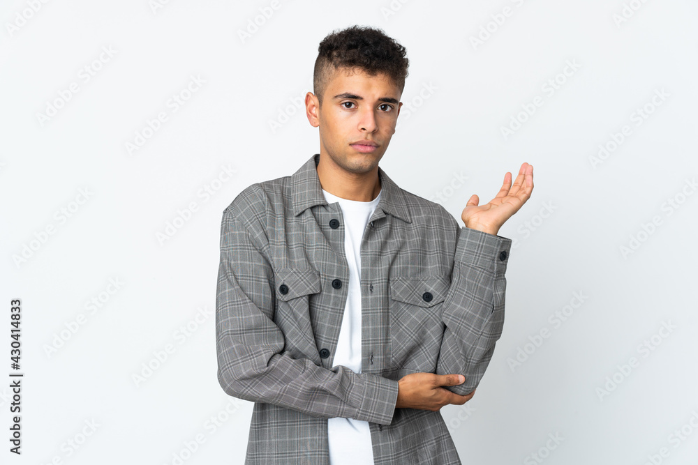 Young brazilian man isolated on white background having doubts Young brazilian man isolated on white background having doubts