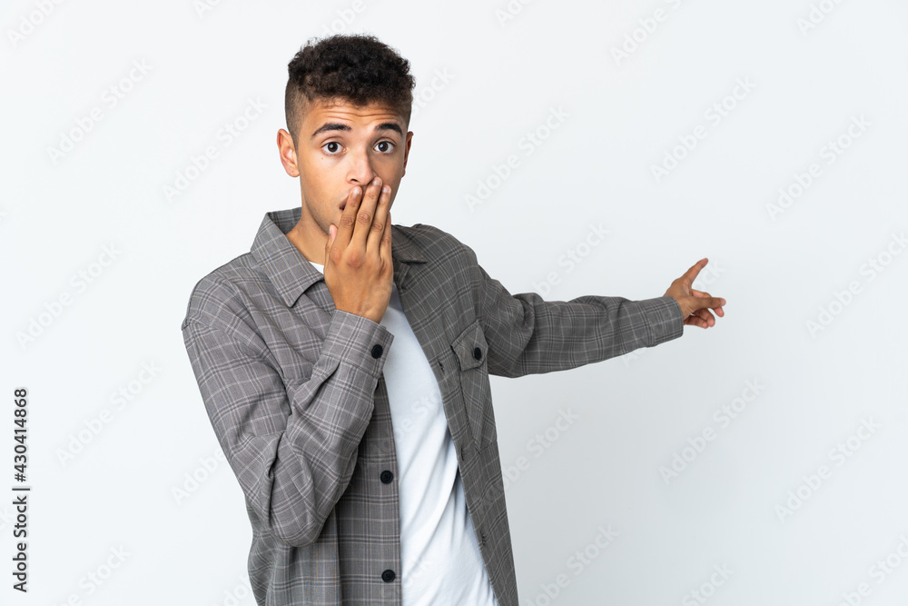 Young brazilian man isolated on white background with surprise expression while pointing side Young brazilian man isolated on white background with surprise expression while pointing side