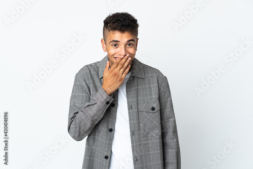 Young brazilian man isolated on white background happy and smiling covering mouth with hand
