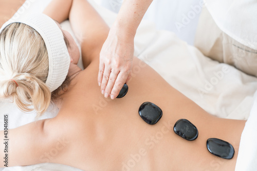 Top view close up picture of young woman lying on massage table and receiving therapeutic spa procedure.