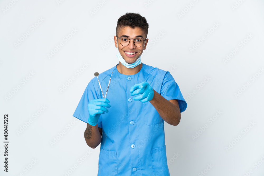 Brazilian dentist holding tool isolated on white background pointing front with happy expression Brazilian dentist holding tool isolated on white background pointing front with happy expression