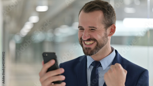 Portrait of Middle Aged Businessman Celebrating Success on Smartphone  © stockbakers