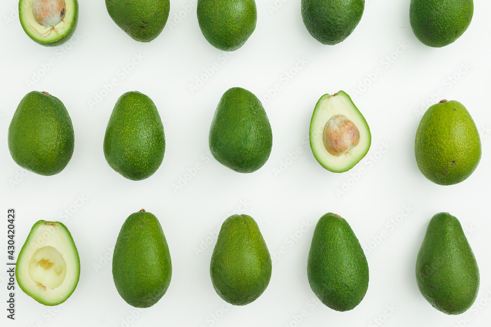 Avocado whole and half pattern on white. Flat lay, top view. Food concept. Avocado whole and half pattern on white. Flat lay, top view. Food concept.