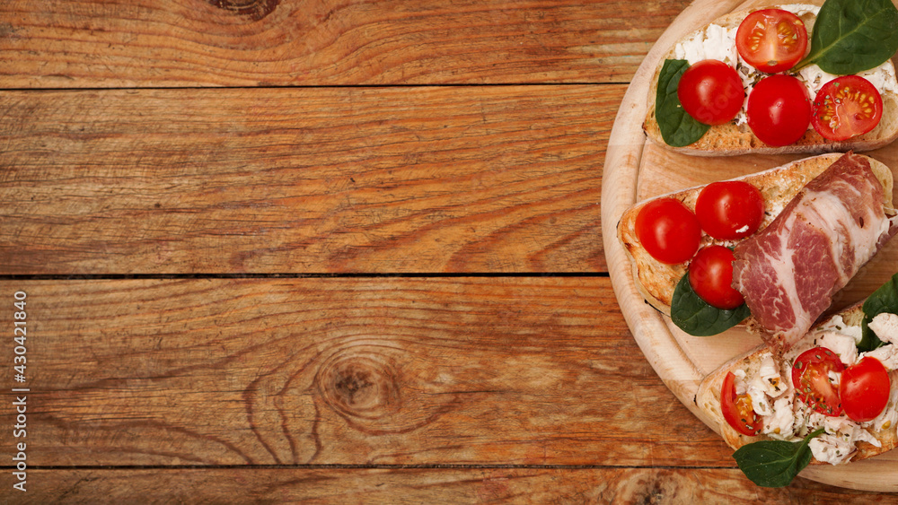 Italian appetizer. Bruschetta on a wooden board on a wooden rustic background Italian appetizer. Bruschetta on a wooden board on a wooden rustic background