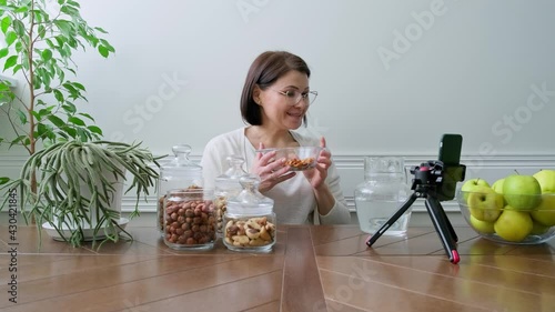 Activation vitamins in nuts. Woman nutritionist soaking nuts in water, consulting online photo