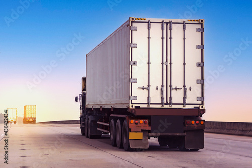 White Truck on highway road with  container, transportation concept.import,export logistic industrial Transporting Land transport on the asphalt expressway against sunrise sky