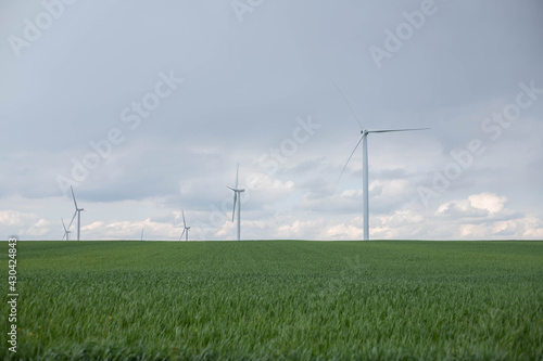 Mills in the field against the blue sky and green grass, saturated photo for the screensaver