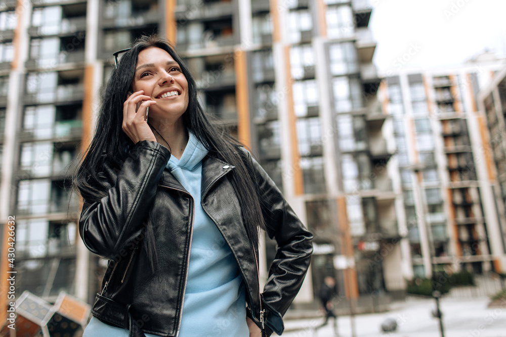 Young beautiful brunette girl talking on the phone and laughing
